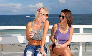 Two stylish girlfriends pose outdoors and fuck with strap-ons indoors